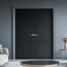 a living room with grey walls and black doors