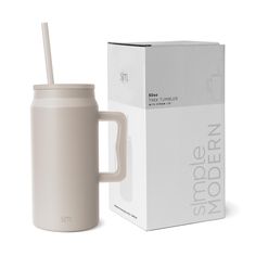 a white mug with a straw in it next to a box