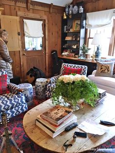 a living room filled with lots of furniture and books on top of a coffee table