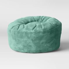 a green bean bag chair sitting on top of a white floor