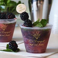 two cups filled with blackberries on top of a table