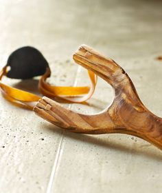 a pair of wooden shoes sitting on top of a floor next to a black shoe