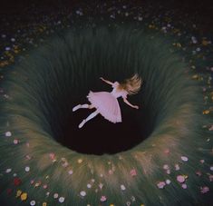 a girl is floating in the middle of a flower filled field