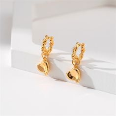 These goldtone earrings show off lovable hearts dangling below. 0.43'' W x 1.06'' L Goldtone copper Heart Silhouette, Huggie Earrings, Huggies Earrings, Gold Plating, Timeless Elegance, Jewelry Collection, 18k Gold, Gold Tones, Gold Plate