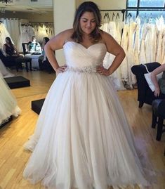 a woman standing in front of a wedding dress