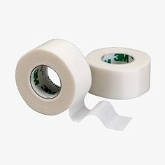 two rolls of white cloth tape with green and white letters on the side, one roll is