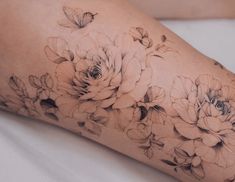 a woman's leg with flowers on it and the words karolinszymanka tattoo