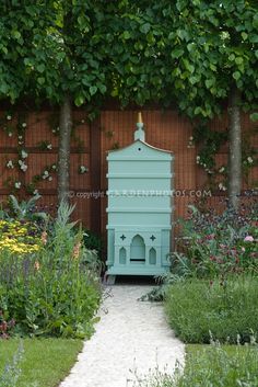 a blue birdhouse sitting in the middle of a garden