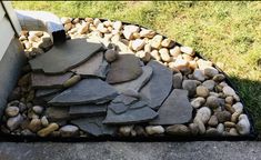 a pile of rocks sitting on top of a sidewalk next to a wall and grass