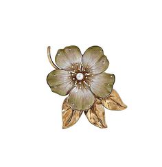 a flower brooch sitting on top of a white surface