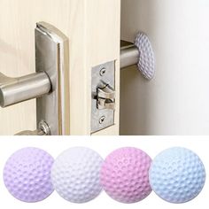 three different colored golf balls are in front of a door handle and an open door