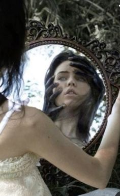 a woman looking at herself in the mirror