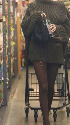 a woman in tights is pushing a shopping cart