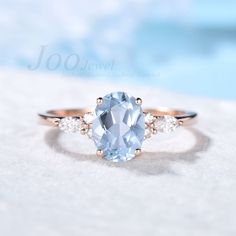 an oval cut blue topazte ring with three diamonds on the band and side stones