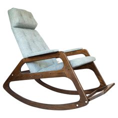 a wooden rocking chair with blue upholstered fabric