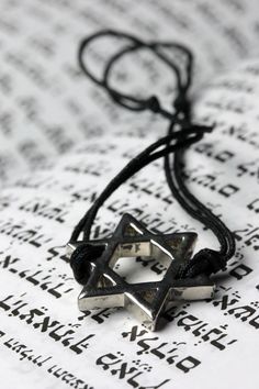 a star of david necklace on top of an open book