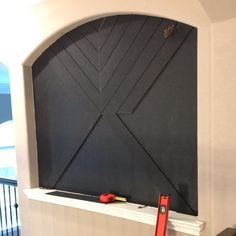 there is a black board on the wall with some tools in front of it and a pair of scissors next to it