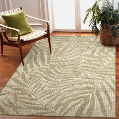 a living room area with a chair, rug and potted plant