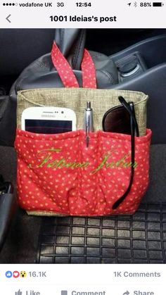 a red purse sitting on top of a car seat next to a cell phone and sunglasses