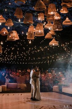 a bride and groom sharing their first dance in front of an audience at a wedding