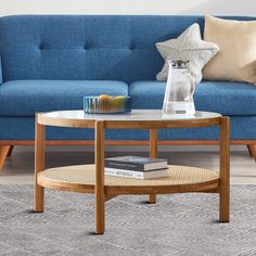 a living room with a blue couch, coffee table and books on the side tables