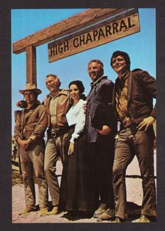 a group of people standing in front of a sign that says high chaparral