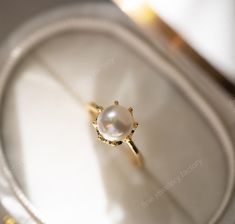 a pearl ring sitting on top of a white tray