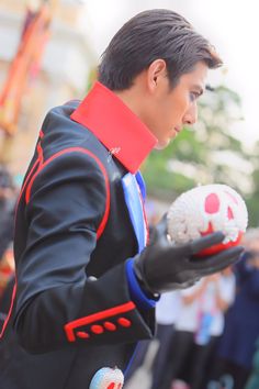 a man dressed in black and red holding a ball