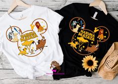 two tshirts with disney characters on them are sitting next to sunflowers