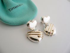 Offered for sale is a gorgeous pair of Tiffany and Co. Sterling Silver & 18K Gold Heart Arrow Dangling earrings. This pair is classic and elegant, and looks very pretty when worn. Extremely versatile and comfortable piece! Great pair to wear for work, a night in town, at a party, or just going to dinner with friends in jeans or a pretty dress. The style is classic Tiffany, making it a piece that you will most certainly use over and over again. No longer in production, you will be one of the few Tiffany And Co Earrings, Gold Heart Earrings, Gold Heart Earring, At A Party, Dinner With Friends, Gift Art, Tiffany And Co, Pretty Dress, Dangling Earrings