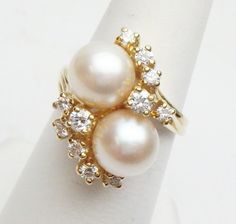 This is a lovely cocktail ring from the 1960s. This ring features 2 cultured Akoya pearls that measure 7.88 - 7.92 mm each. One pearl has a slightly more pink-ish tone than the other. The ring also has 11 full cut round diamonds that graduate from 2.65 down to 2.00 mm for an estimated combined weight of 0.37 carats in all. Diamonds have VS1 clarity and G color. Ring is stamped 18K and weighs 6.4 grams. Ring is a size 6. * Sizing is available. Please message us for a quote * *We are always willin Pearl Cocktail Ring, Akoya Pearls, Pretty Rings, Color Ring, Cluster Ring, Cocktail Ring, Yellow Gold Rings, Cocktail Rings, Rings Statement