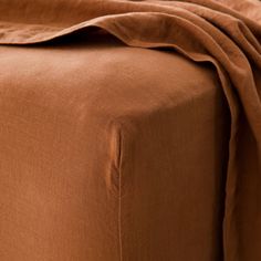 a bed with a brown blanket on top of it