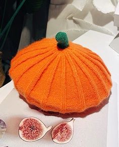 an orange knitted hat, sunglasses and figurines are sitting on a table