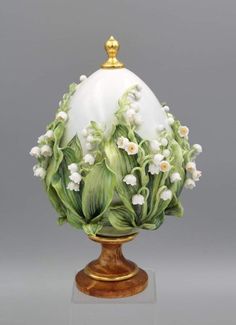 an egg decorated with white flowers and green leaves