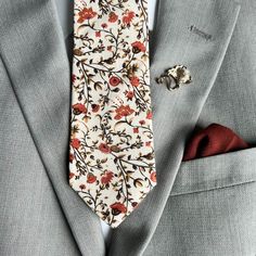 a tie and cufflinks are sitting on a suit jacket with a red pocket square