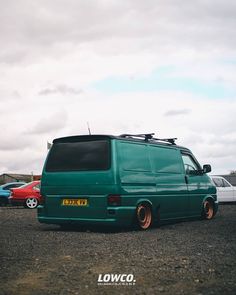 a green van parked on top of a parking lot