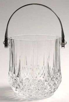 a clear glass basket with metal handles on a white background, it appears to be an old fashioned ice bucket