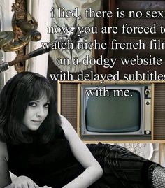 a woman sitting on the floor in front of a tv with an old fashioned television behind her