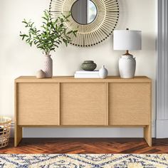 a living room with a large mirror and vases on the sideboard next to it