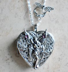 Fairy music box pendant. This heart shaped music box pendant is inspired by the gorgeous music box pendants of era's gone by. Music box is pill box size, please look at the dimensions for exact size.A perfect silver tone heart locket has been adorned with a layer of filigree and silver fairy with purple rhinestone on her wings. The filigree and fairy have been finished with resin to preserve the beauty of this pendant.The music box winds from a key on the back of the pendant. The pendant hangs f Fairy Music, Music Box Locket, Heart Shaped Locket, Ella Enchanted, Silver Fairy, Round Locket, Purple Rhinestone, Funky Jewelry, Unique Jewelry Designs