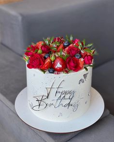 a birthday cake with strawberries and blueberries on it