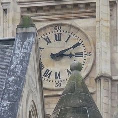 a large clock on the side of a building with roman numerals around it