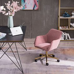 a pink chair sitting next to a desk with a laptop on it