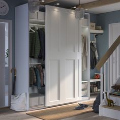 an open closet with clothes hanging on the door and shoes sitting on the floor next to it