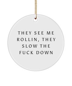 a white ornament with the words they see me rollin, they slow the f