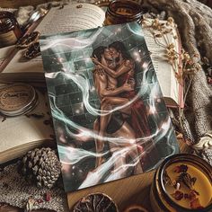 an open book sitting on top of a wooden table next to other items and decorations