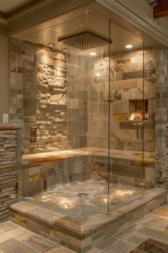 a walk in shower sitting next to a stone wall and tiled floor with lights on it