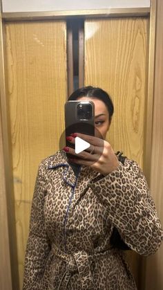 a woman taking a selfie in front of a mirror with her cell phone up to her ear