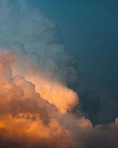 an airplane is flying through the clouds at sunset