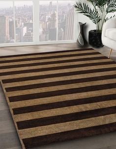 a brown and black rug in a living room with large window overlooking the city skyline